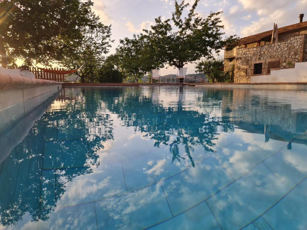 een zwembad met een weerspiegeling van de lucht in het water bij Villa Graziella in Magione