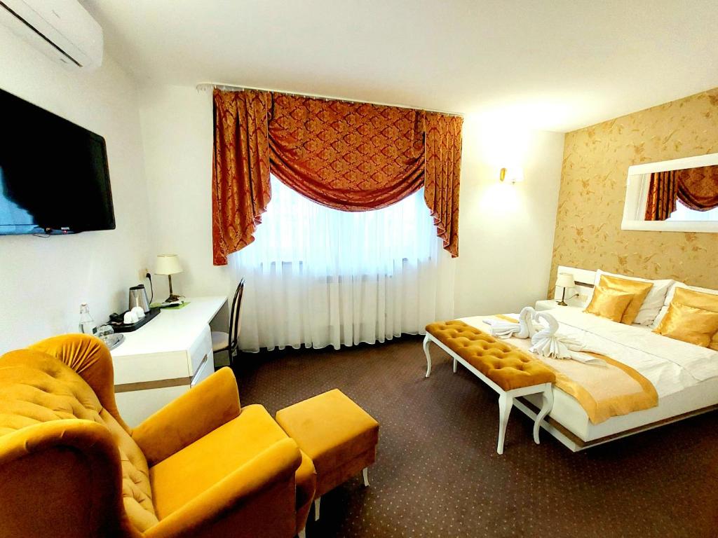 a hotel room with a bed and a couch and a window at Hotel u Liska in Kutno