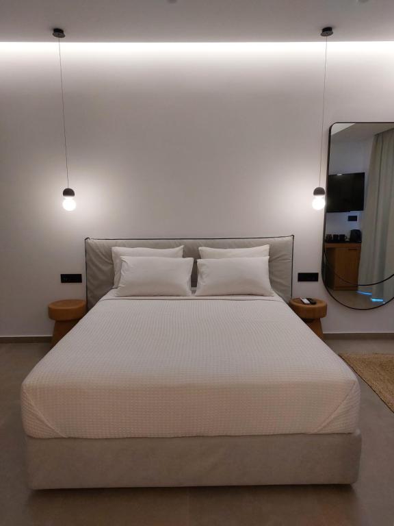 a bedroom with a large white bed with a mirror at Anastasia Apartments in Balíon