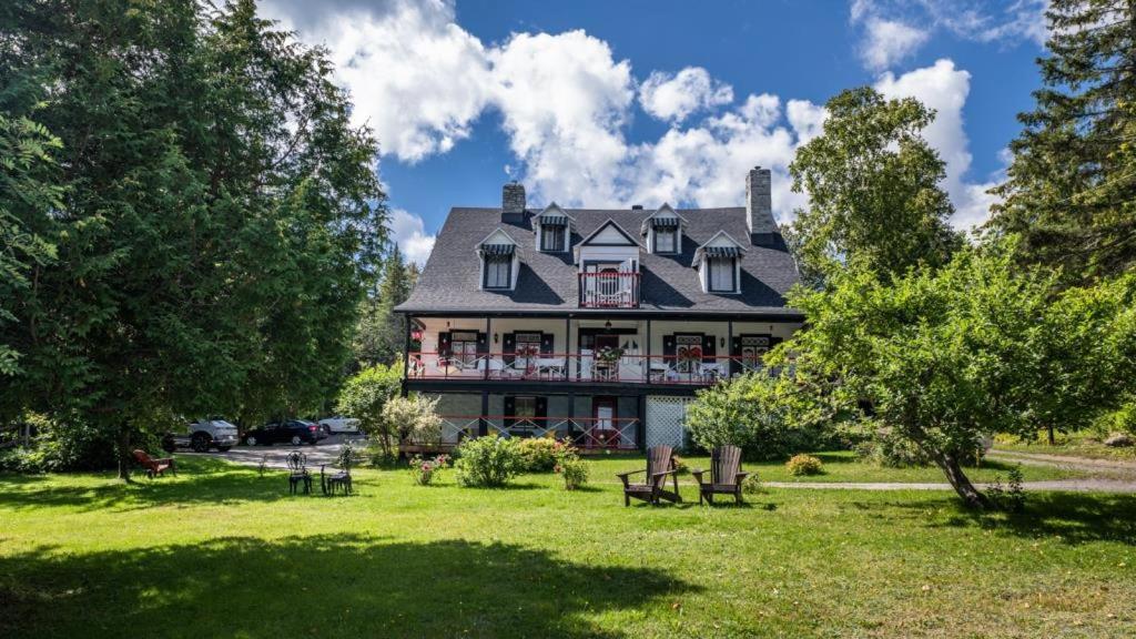 a large house with a lawn in front of it at Auberge La Châtelaine in La Malbaie