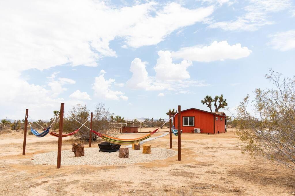 un parque infantil con hamacas en medio de un campo en Cryptic Cabin-Tranquil Bohemian Getaway w/Hot Tub, en Yucca Valley