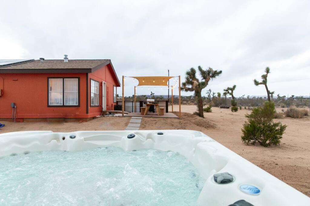 a hot tub in front of a house in the desert at Hemingway House - Hot Tub Under The Desert Stars in Yucca Valley