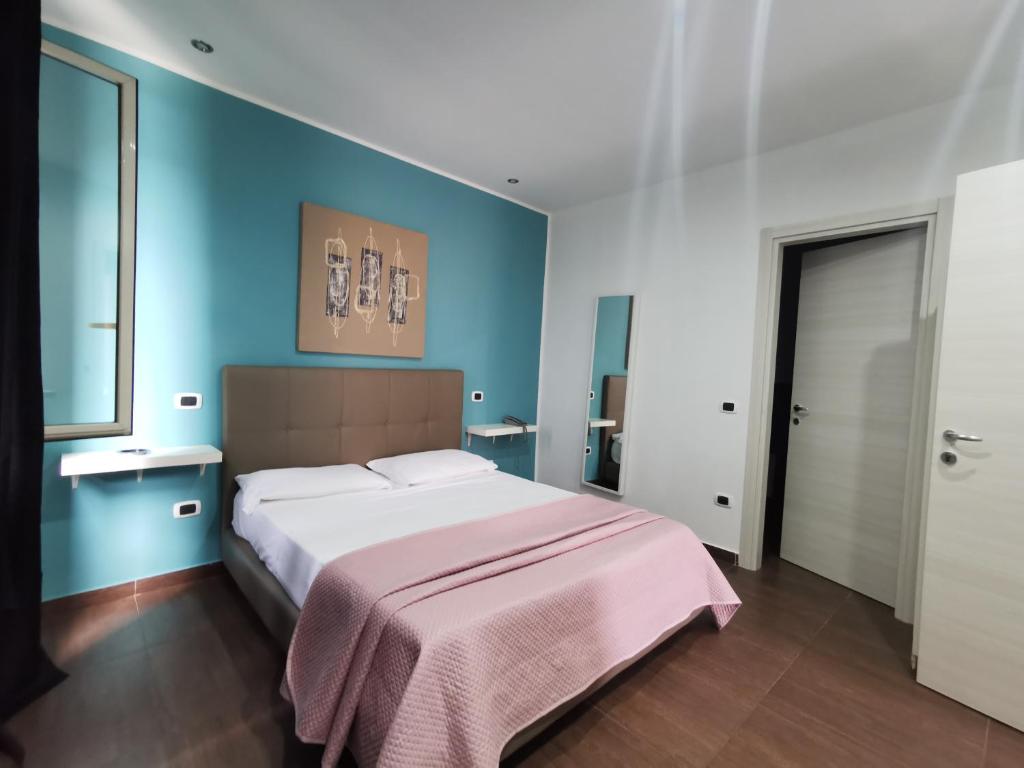 1 dormitorio con 1 cama grande y paredes azules en Hotel Glem, en Varcaturo