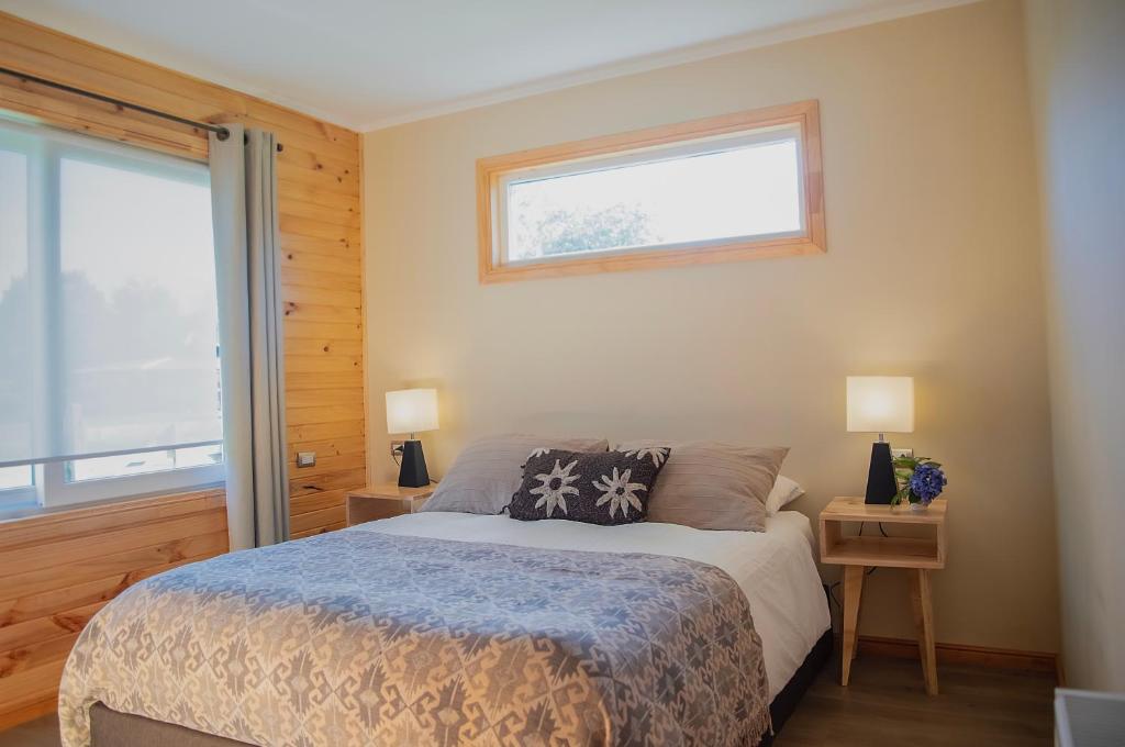 a bedroom with a bed and a window at Hostal Vuelta al Sur in Puelo