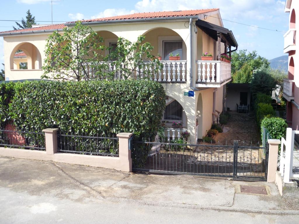 a house with a fence in front of it at Apartments with a parking space Pinezici, Krk - 15269 in Vrh