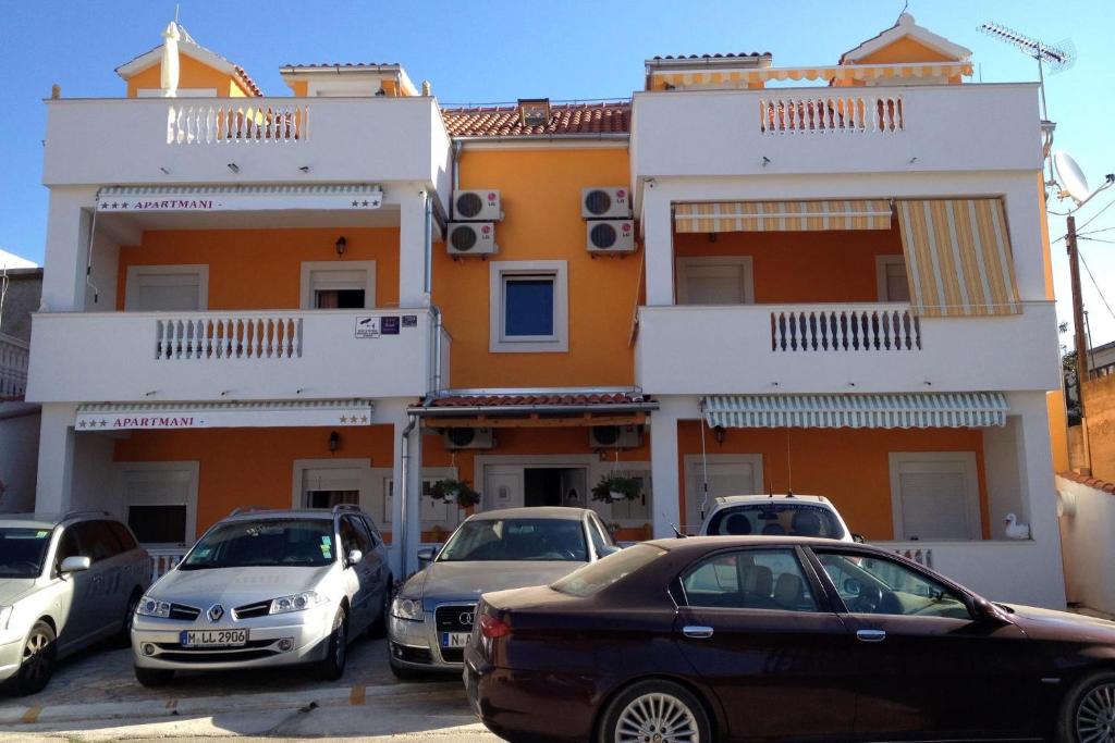 a group of cars parked in front of a building at Apartments with a parking space Pirovac, Sibenik - 15271 in Pirovac