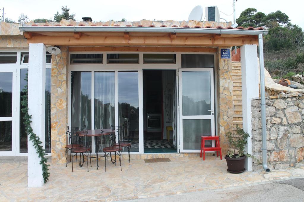 a house with a patio with a table and chairs at Apartments with a parking space Mali Iz (Iz) - 15278 in Veli Iž
