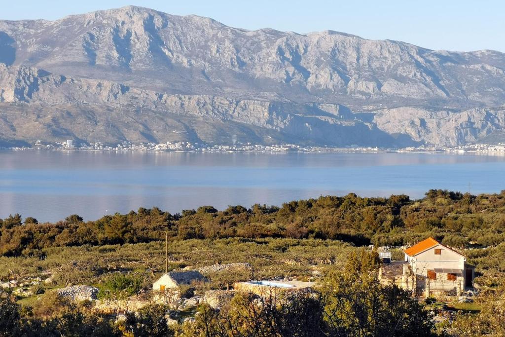 une vue d'un lac avec des montagnes en arrière-plan dans l'établissement Family friendly house with a swimming pool Skrip, Brac - 15297, à Supetar