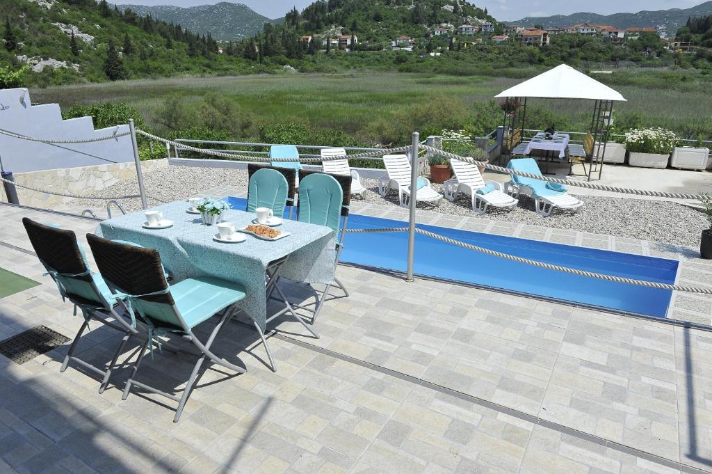 a table and chairs sitting on top of a patio at Family friendly apartments with a swimming pool Bacina, Neretva Delta - Usce Neretve - 15309 in Ploče