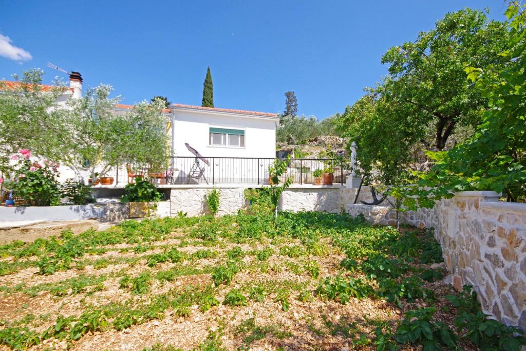 een huis aan de zijkant van een heuvel met bomen bij Holiday house with WiFi Trogir - 15319 in Trogir