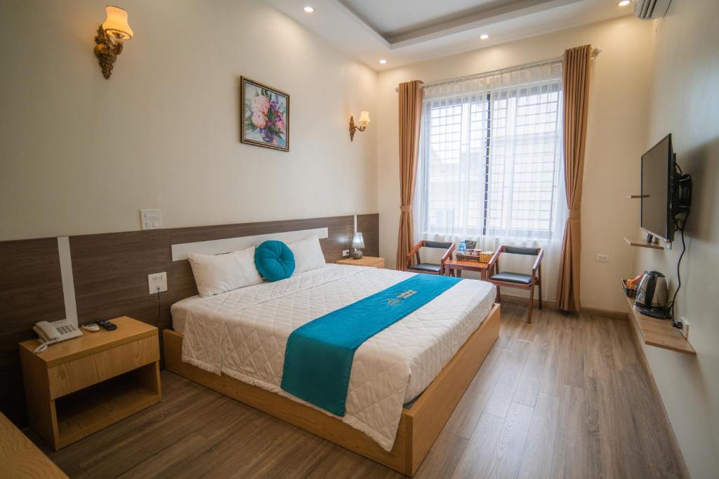 a bedroom with a large bed and a television at Noi Bai Boutique Hotel in Hanoi