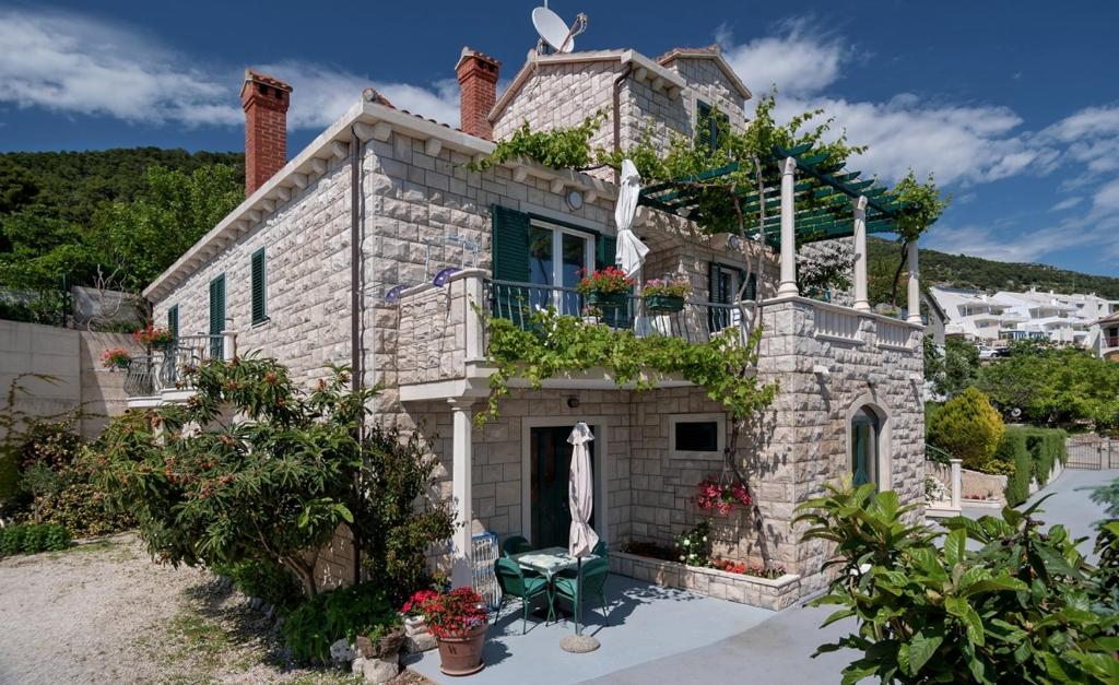 a stone house with a balcony on top of it at Apartments and rooms with parking space Bol, Brac - 15418 in Bol