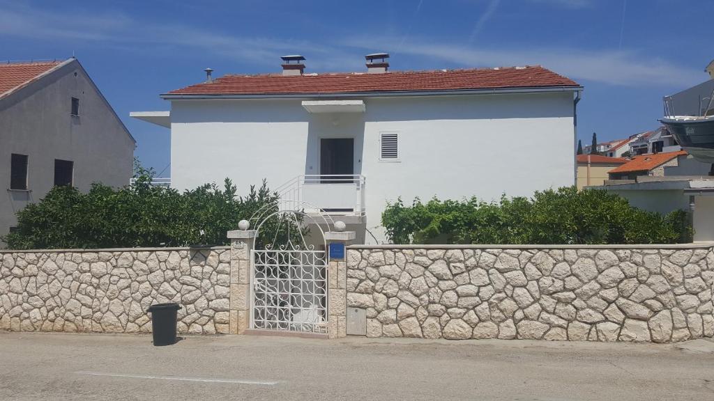 a white house with a stone wall and a fence at Double Room Hvar 15378a in Hvar