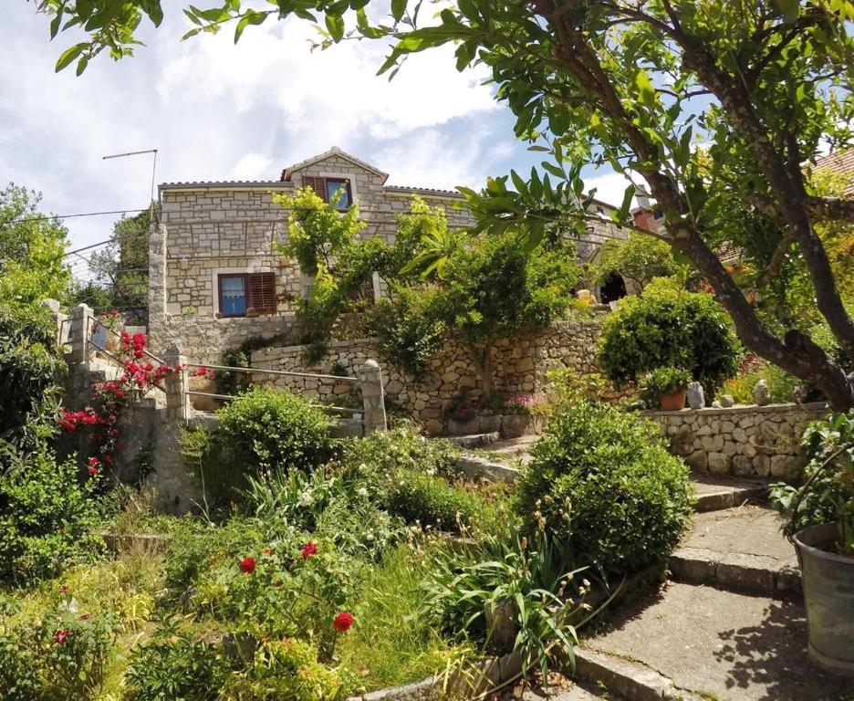 a stone house with a garden in front of it at Holiday house with a parking space Lozisca, Brac - 15444 in Ložišće