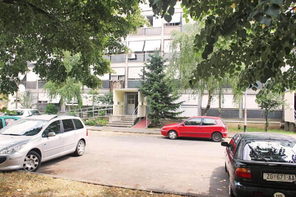 札格雷布的住宿－Apartments with WiFi Zagreb - 15474，两辆汽车停在大楼前的停车场