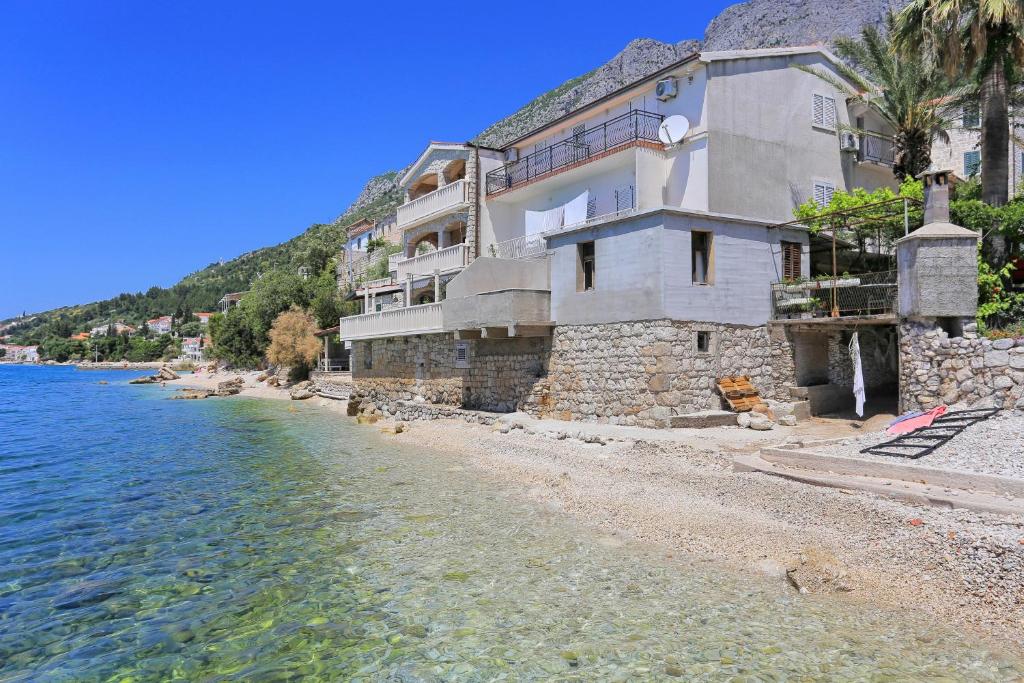 ein Gebäude am Ufer eines Wasserkörpers in der Unterkunft Apartments by the sea Brist, Makarska - 15465 in Brist