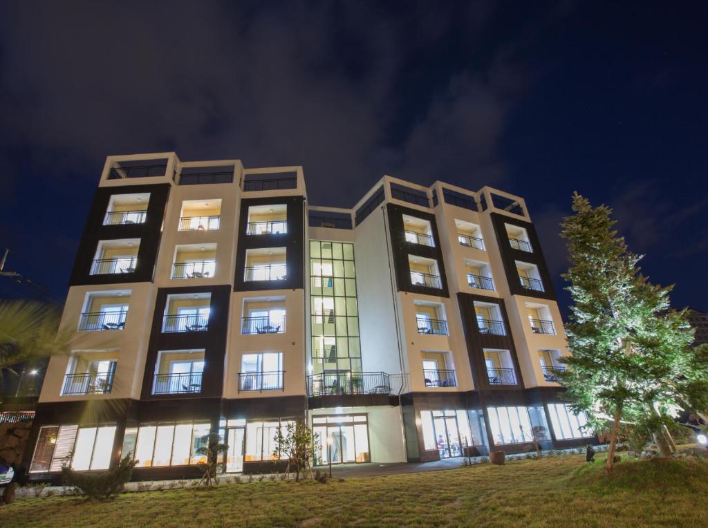 un edificio de apartamentos por la noche con sus luces encendidas en Fellisia Hotel, en Seogwipo