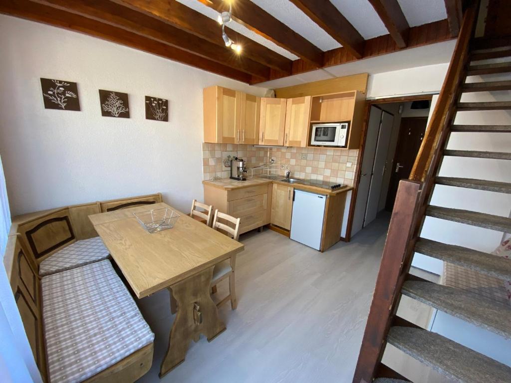 een kleine keuken met een houten tafel en een trap bij Appartement 2 pièces avec mezzanine près des pistes - 6 personnes - FR-1-815-81 in Morillon