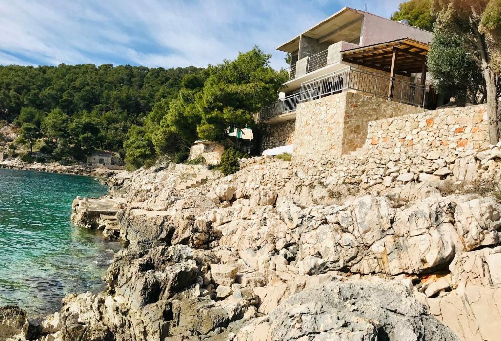 una casa en un acantilado rocoso junto al agua en Secluded fisherman's cottage Cove Lucica, Hvar - 15546 en Gdinj