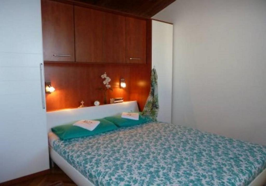 a small bedroom with a bed with a wooden headboard at Apartments by the sea Kaprije - 15567 in Kaprije