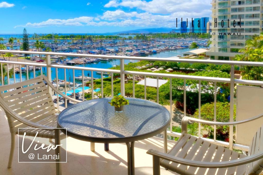 a balcony with a table and chairs and a harbor at New Aloha Ilikai 1free Parking in Honolulu