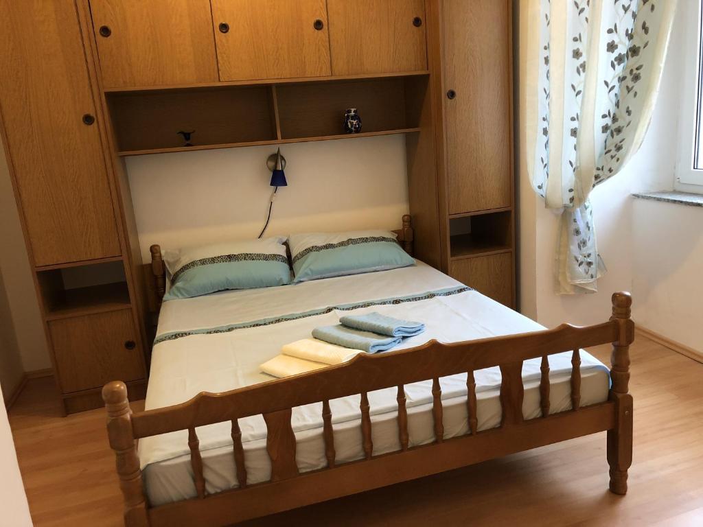 sypialnia z łóżkiem i drewnianymi szafkami w obiekcie Apartments by the sea Senj - 15578 w mieście Senj