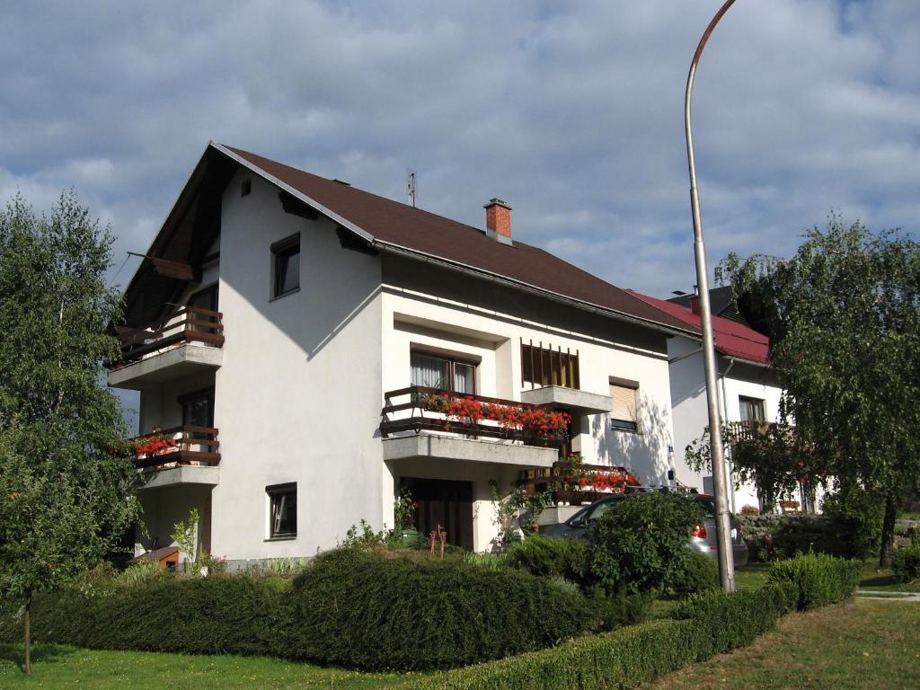 a white house with balconies and a street light at Apartments with a parking space Delnice, Gorski kotar - 15589 in Delnice