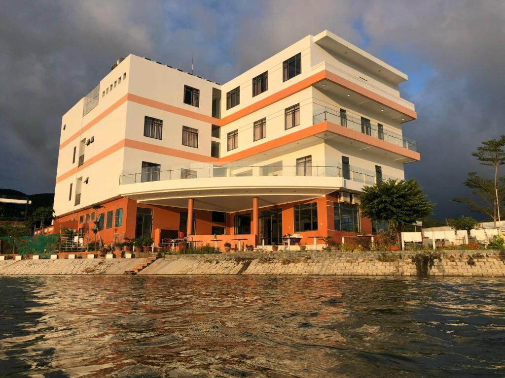 un bâtiment à côté d'une masse d'eau dans l'établissement Chau Gia Hotel, à Vĩnh Hy