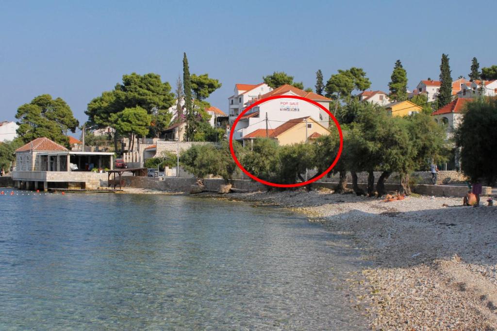 a red circle sitting on the side of a river at Apartments by the sea Sutivan, Brac - 15617 in Sutivan