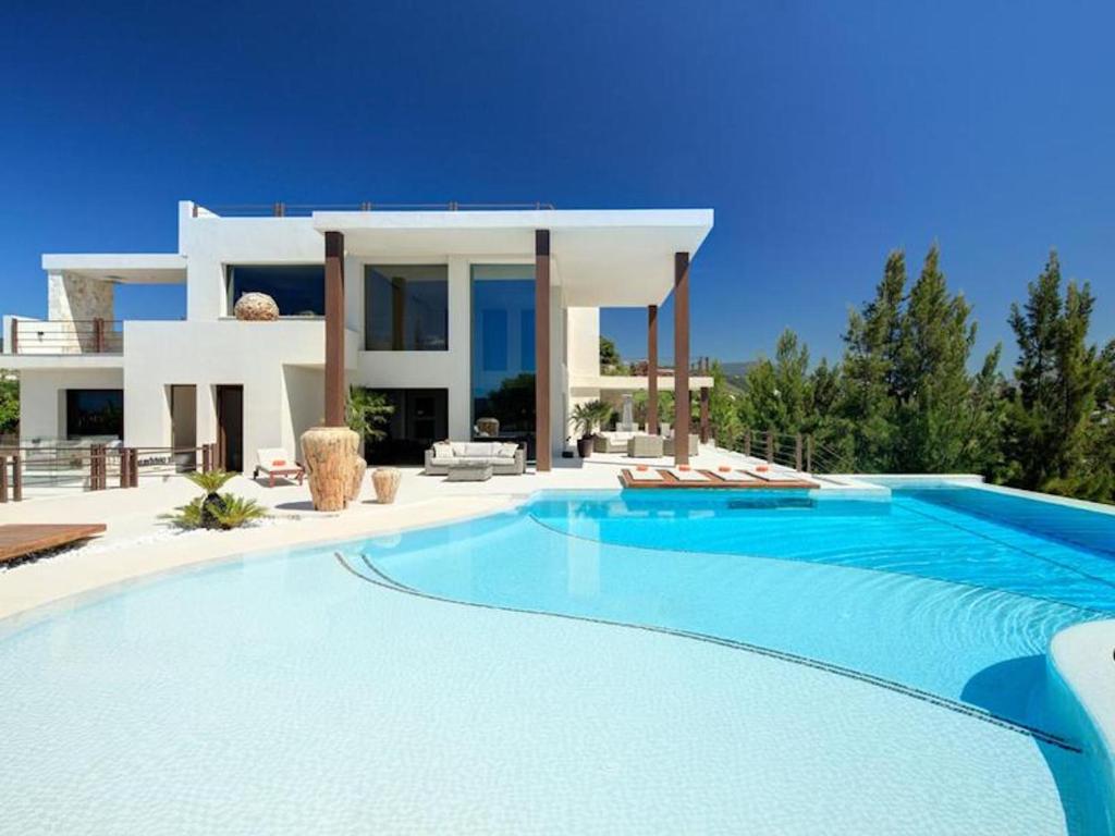 エステポナにあるContemporary Villa, Golf La Alquería, Benahavis, Marbellaのヴィラの前に広いスイミングプールがあります。