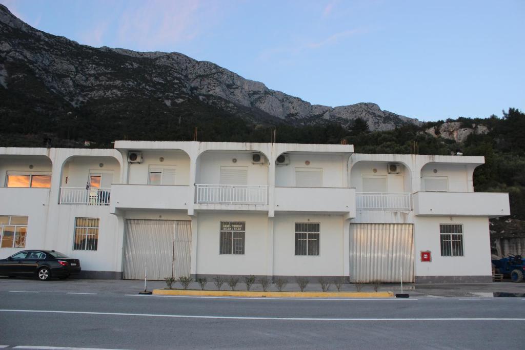a white building with a car parked in front of it at Apartments with a parking space Gradac, Makarska - 15628 in Gradac