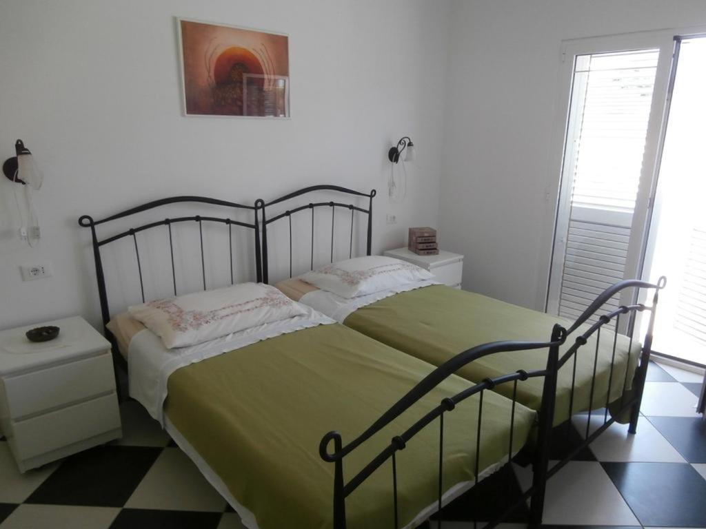 a bedroom with a large bed with a green blanket at Apartment Sevid 15664a in Sevid