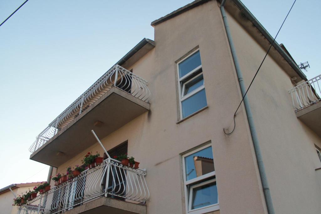un edificio con balcones y macetas. en Studio Brodarica 15708b, en Ražine