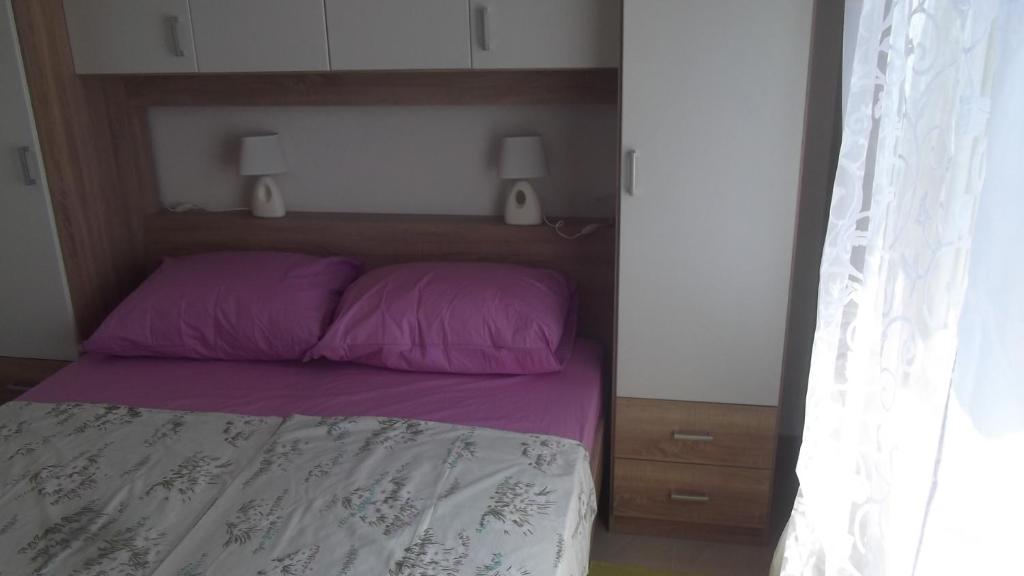 sypialnia z łóżkiem z fioletową pościelą i 2 głośnikami w obiekcie Apartments with WiFi Podstrana, Split - 15970 w Podstranie