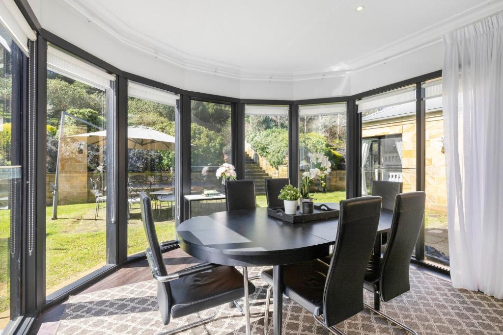 a dining room with a black table and chairs at Sandstone Estate in Red Hill