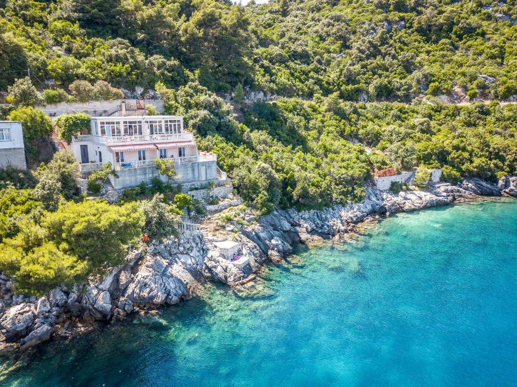 an aerial view of a large house on a rocky shore at Apartments by the sea Sobra, Mljet - 15993 in Babino Polje