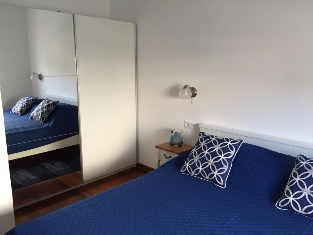 a bedroom with a blue bed and a mirror at Apartments with a parking space Podstrana, Split - 16032 in Podstrana