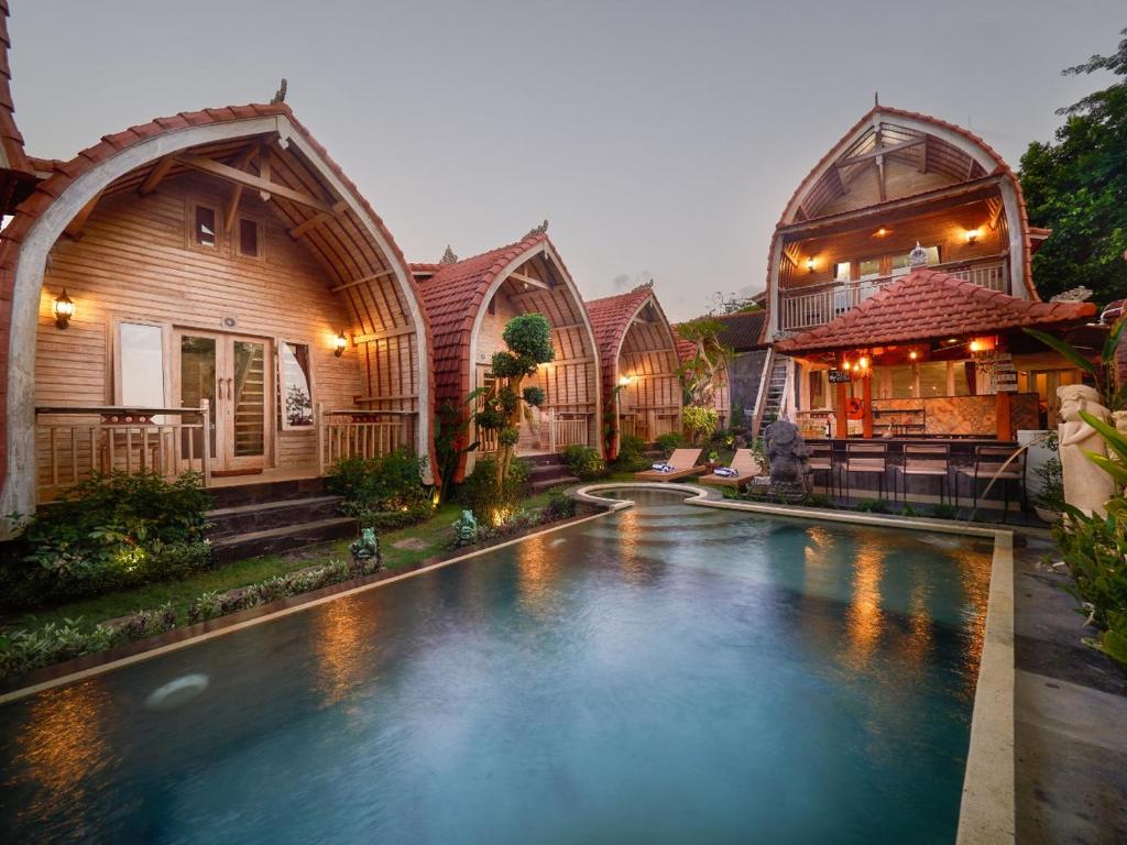 a house with a swimming pool in front of a house at Wisnu Lumbung Uluwatu in Uluwatu