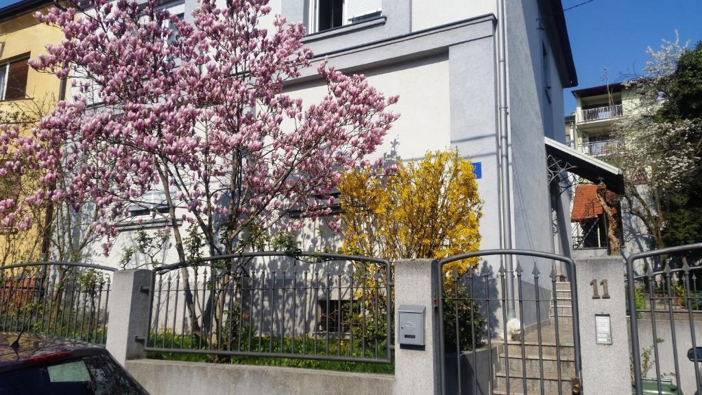 un árbol con flores rosas delante de una valla en Apartments with WiFi Zagreb - 16085, en Zagreb