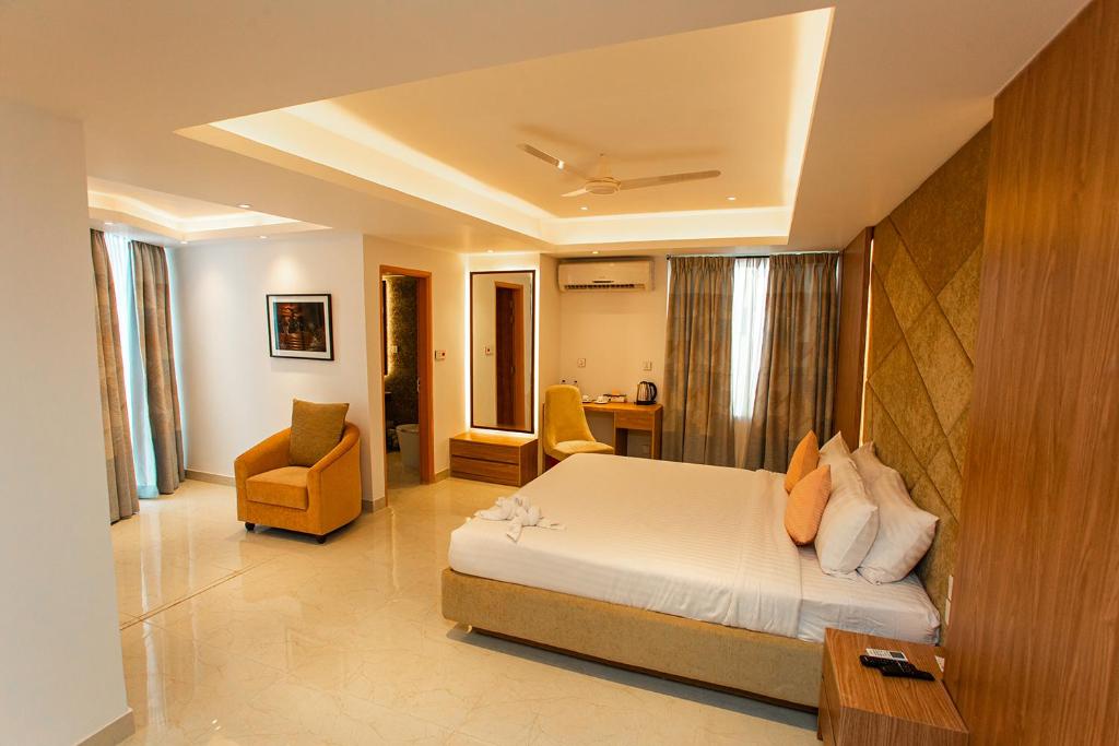 拉傑沙希的住宿－Royal Raj Hotel，卧室配有一张床、一张桌子和椅子