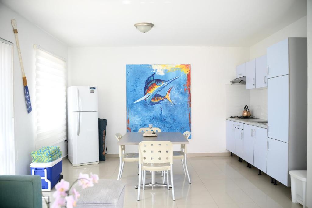 a kitchen with a table and a painting on the wall at Beach Homes Aruba in Noord