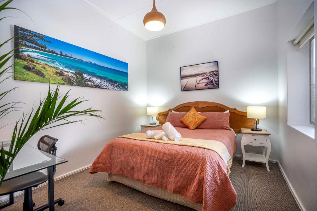 een slaapkamer met een bed en twee lampen en een plant bij One-Bedroom Apartment on Summer in Orange