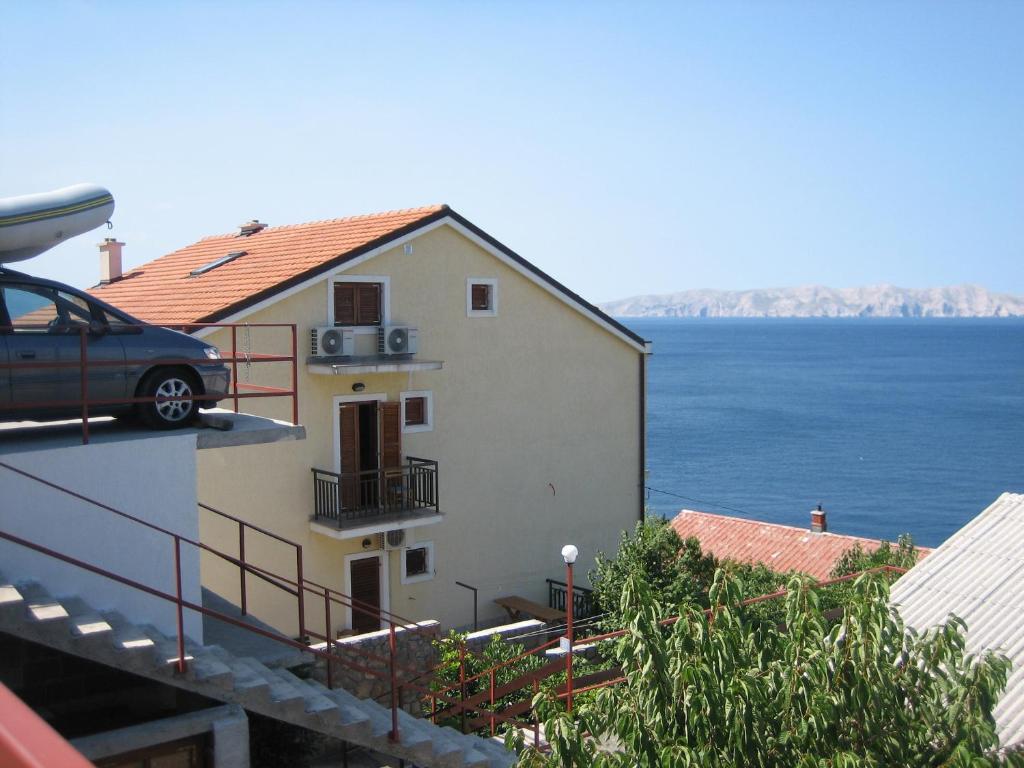 a car parked on the side of a building next to the water at Apartments with parking space Senj - 15376 in Senj