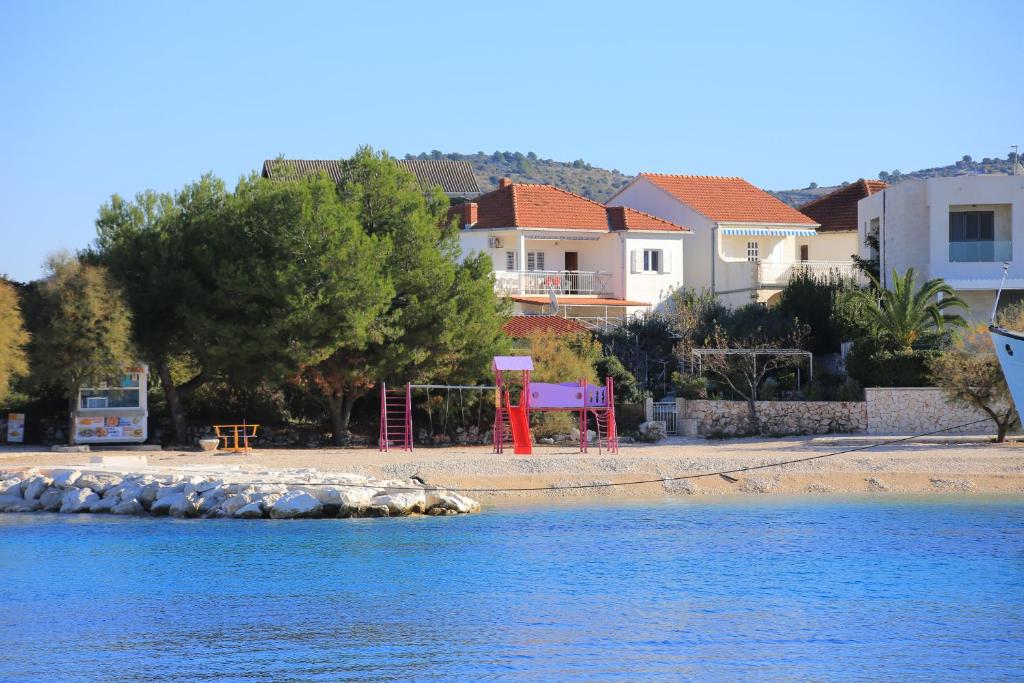 a view of a beach with houses and the water at Apartments by the sea Rogoznica - 16216 in Rogoznica