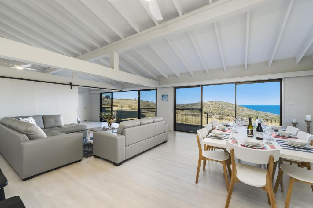 Un comedor y una sala de estar con mesa y sillas. en Ocean Paradise, en Bonny Hills