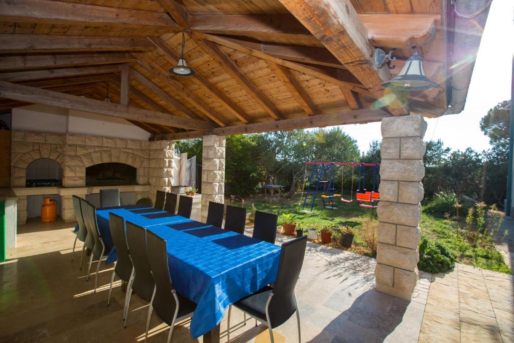 a long table with chairs and a blue table cloth at Apartments with parking space Barbat, Rab - 16245 in Rab
