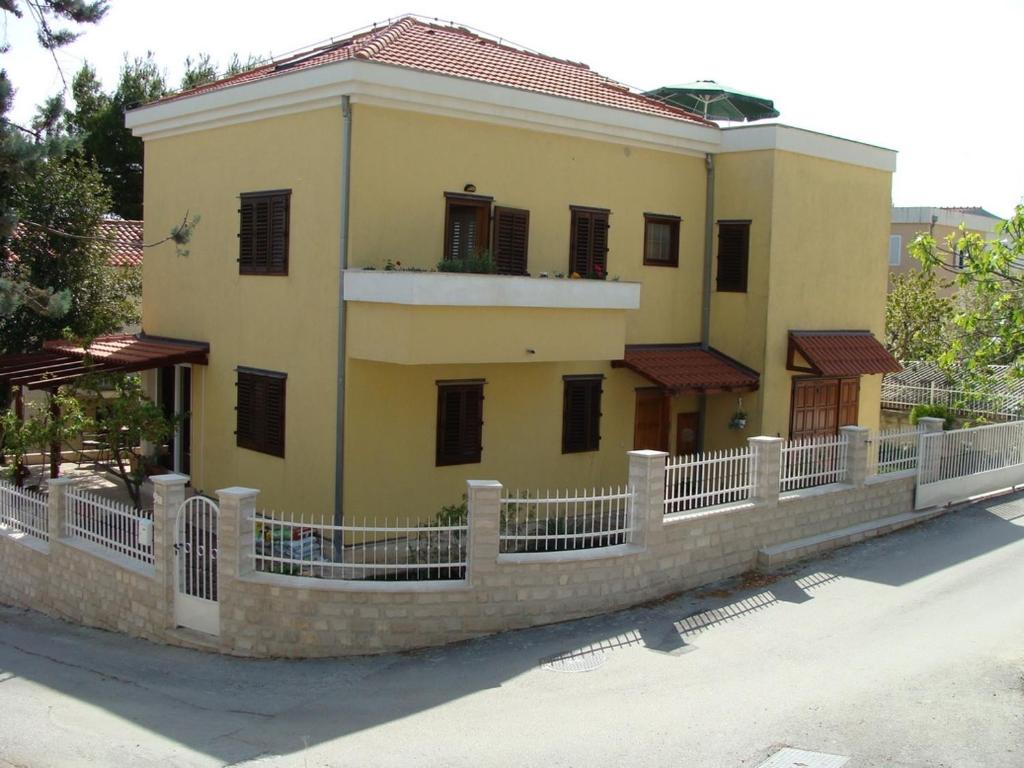 a yellow house with a fence in front of it at Apartments with a parking space Split - 16247 in Split