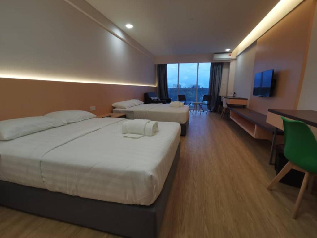 Cette chambre comprend 2 lits et une télévision à écran plat. dans l'établissement deCore, à Kota Kinabalu
