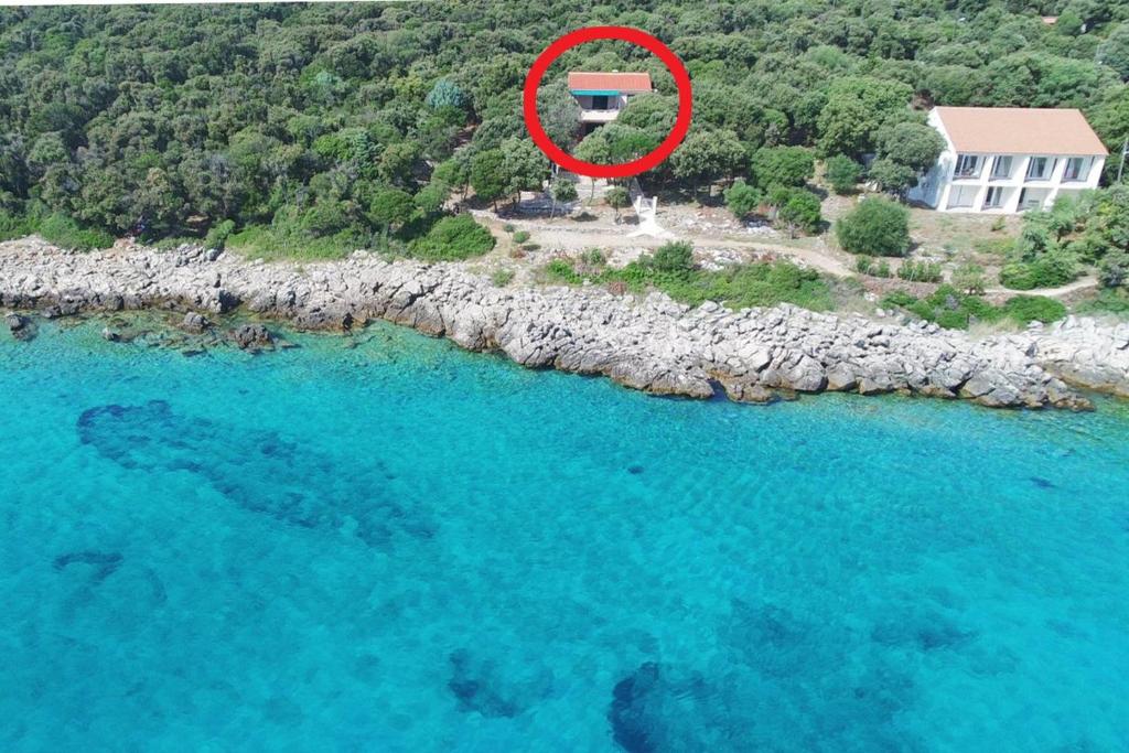 eine Luftansicht eines Hauses mit rotem Kreis in der Unterkunft Apartments by the sea Cove Mulobedanj, Pag - 16285 in Lun