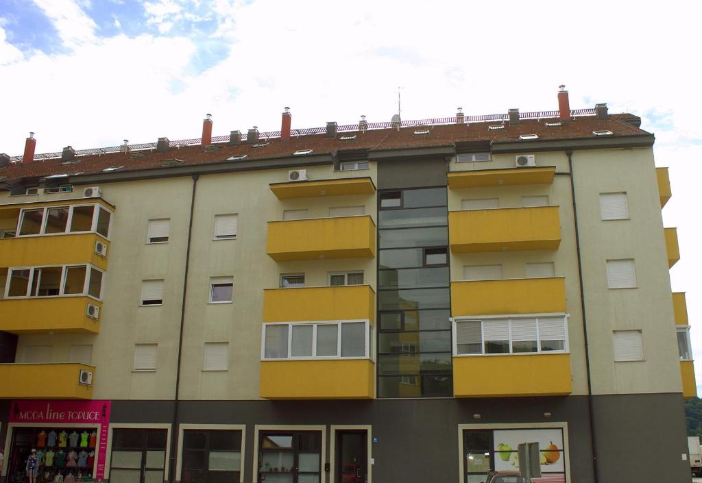 an apartment building with yellow windows on the side of it at Apartments with a parking space Krapinske Toplice, Zagorje - 16290 in Krapinske Toplice